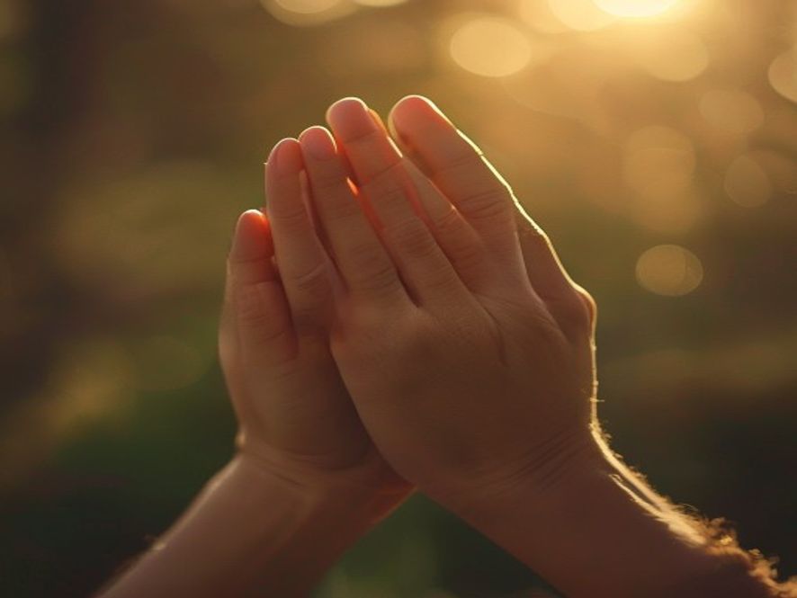 A pair of hands held in prayer, soft focus, suggesting humility and a heart seeking guidance.